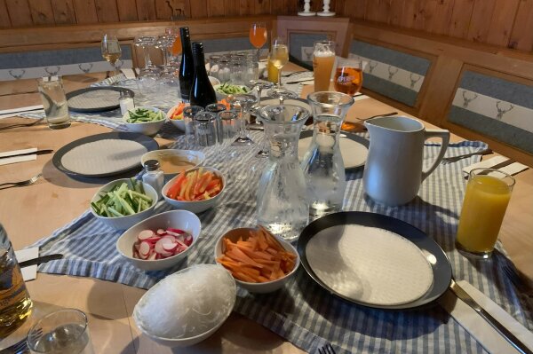 Gedeckter Tisch mit Gemüse und Reisblättern zum Befüllen.