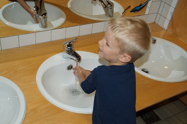 Junge wäscht Hände.