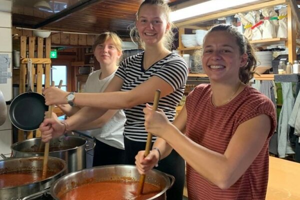 Botschafterin Annika mit zwei Kolleginnen beim Rühren einer Tomatensuppe.