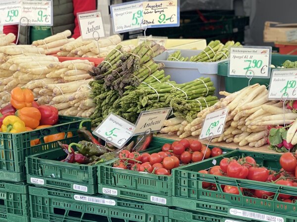 Marktstand mit weißem und grünem Spargel, Tomaten und Paprika