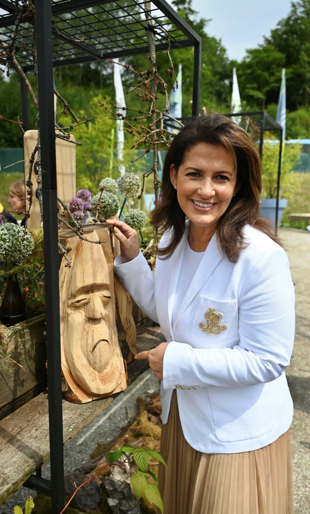 Ministerin Michaela Kaniber auf der Landesgartenschau in Freyung mit einem in Holz geschnitztem Gesicht.