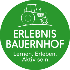 Mädchen kniet vor Kühen, die fressen; eingeblendet Logo und Schriftzug Erlebnis Bauernhof