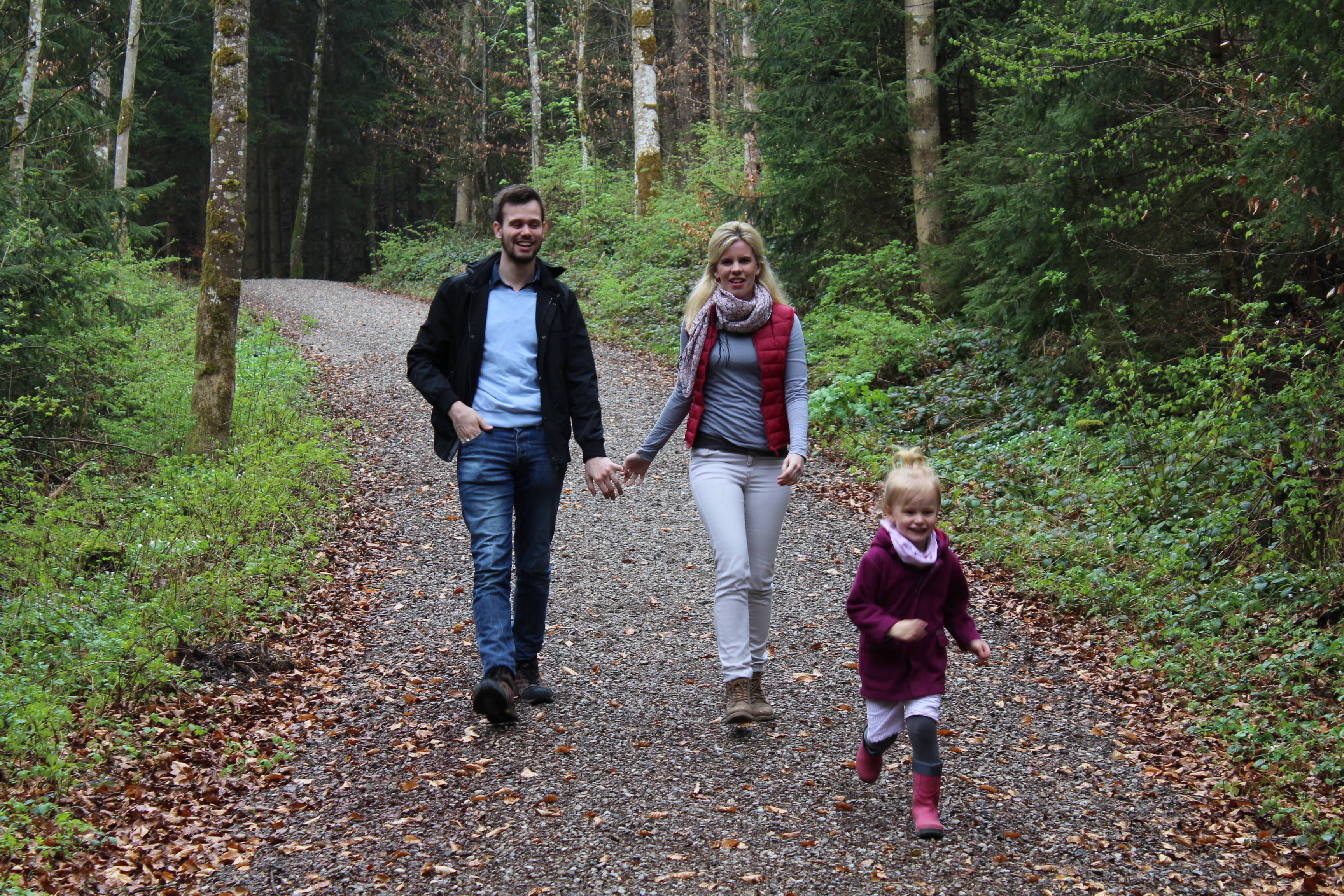 Kleinfamilie mit Kind beim Waldspaziergang