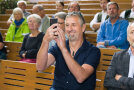 Mann im Publikum macht mit dem Handy ein Foto