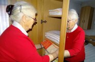 Seniorin räumt Handtuch in einen Schrank