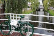 Ein grünes Fahrrad an einer Brücke über einen Fluss