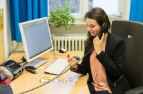 Eine junge Frau telefoniert in einem Büro