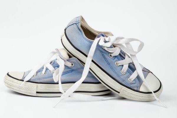 Ein paar blaue Stoffschuhe vor weißem Hintergrund