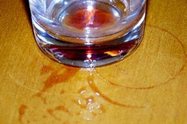 Glas mit Saftresten und Saftflecken auf Tisch