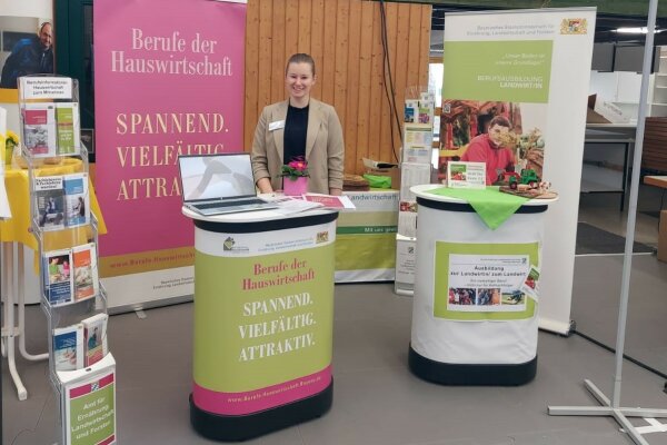 Leonie steht an einem Messestand für Berufswerbung.