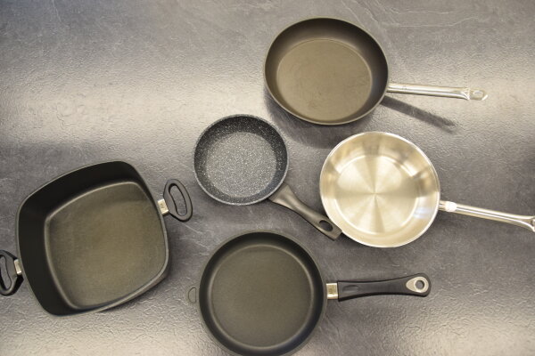 Verschiedene Pfannen unterschiedlicher Art stehen nebeneinander.