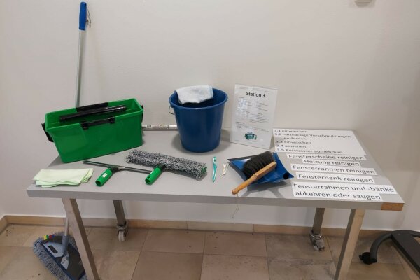 Aufgebaute Station mit Reinigungsutensilien in einem Klassenzimmer