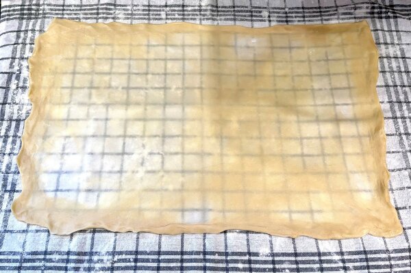 Ein dünn ausgezogener Strudelteig auf einem Küchentuch