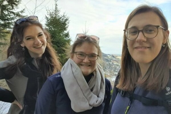 Zwei Mädchen mit Botschafterin Johanna beim Bergwandern.