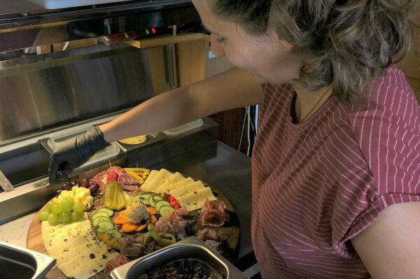 Annika belegt in der Küche eine Brotzeitplatte