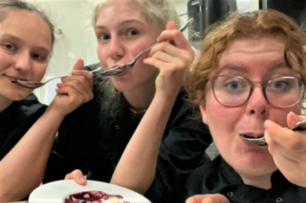 Emma und zwei Freundinnen löffeln eine Nachspeise