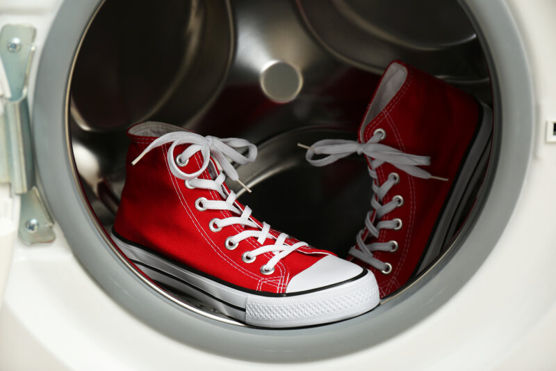 Ein paar roter Stoffschuhe in einer geöffneten Waschmaschinentrommel