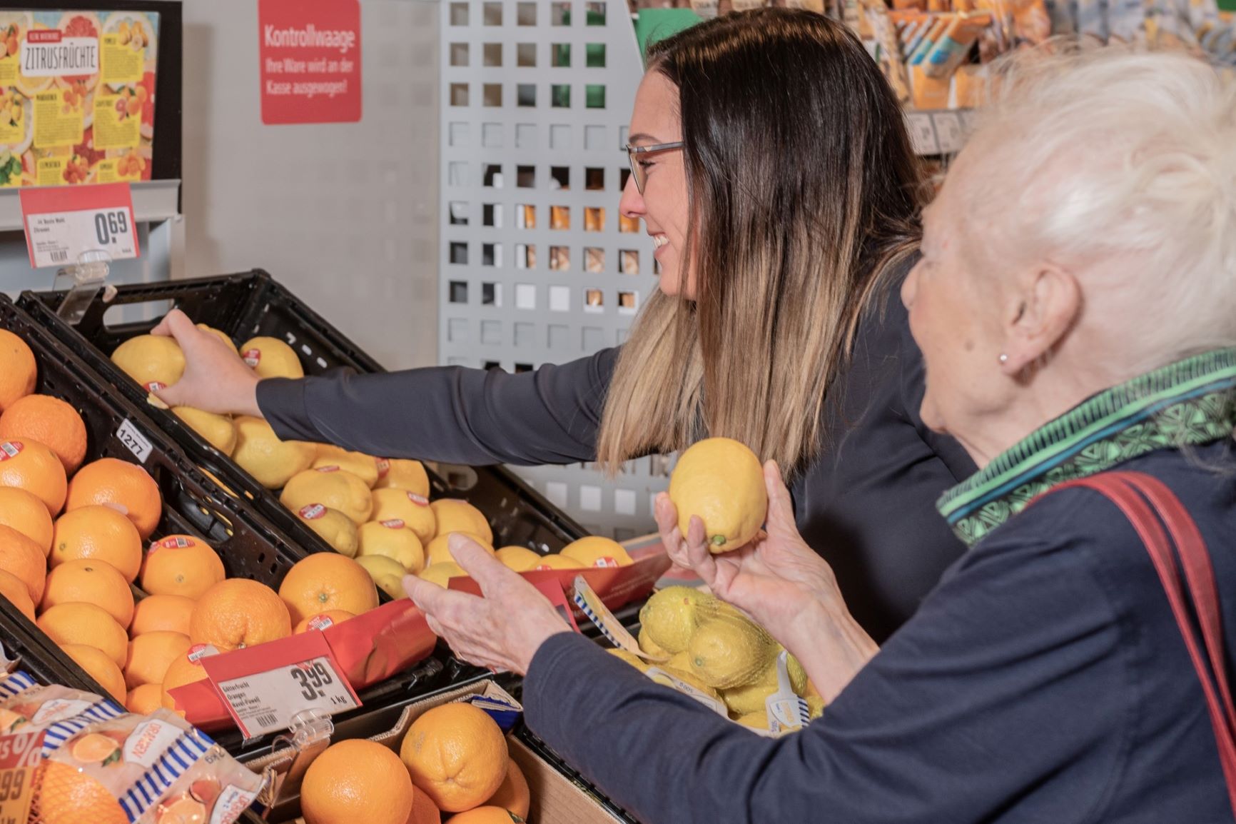 Junge Frau und Seniorin an einem Obstregal im Supermarkt