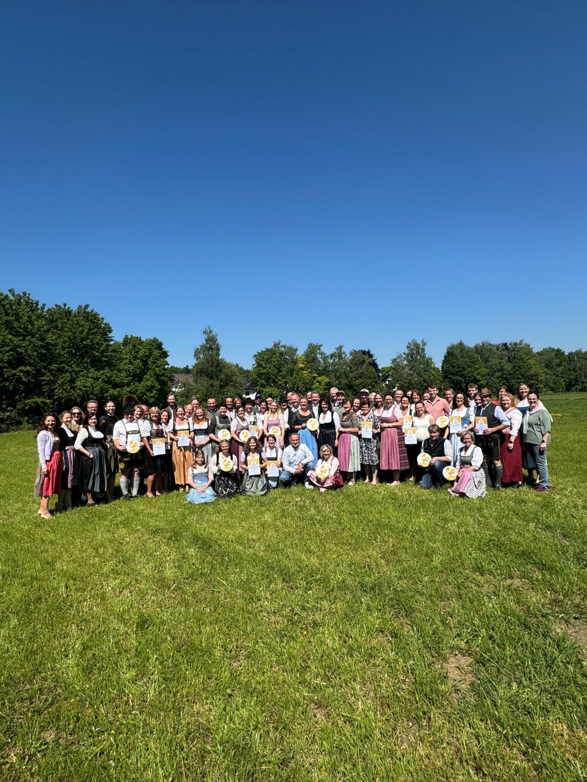 Das Bild zeigt Staatsministerin Michaela Kaniber gemeinsam mit allen Preisträgern auf einer Wiese  mit blauem Himmel im Hintergrund. 