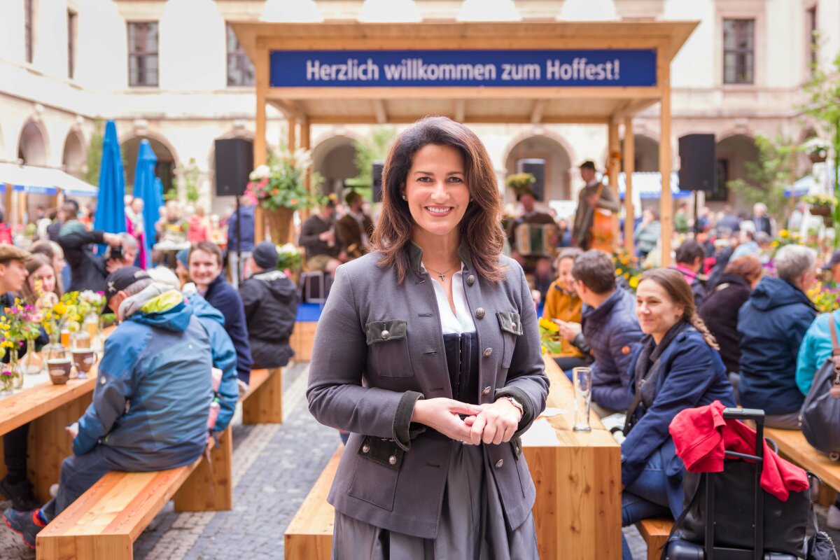 Ministerin Kaniber auf dem Hoffest. Im Hintergrund die Musikbühne und Gäste.