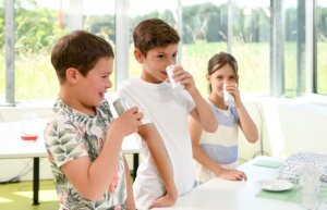 Drei Kinder riechen an Dosen mit Gewürzen 