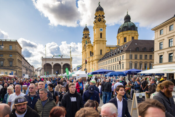 Viele Menschen auf der Bauernmarktmeile in München. Im Hintergrund die Feldherrnhalle und die Theatinerkirche