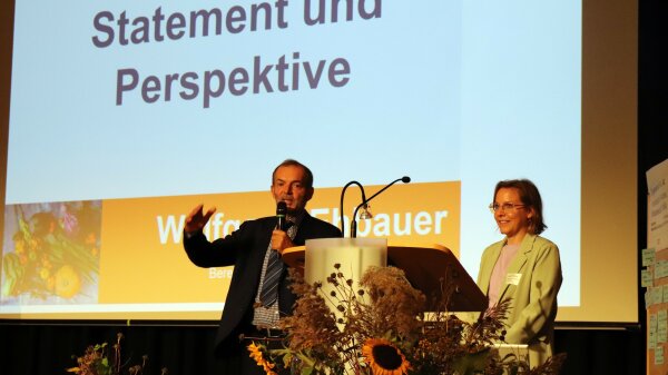 Wolfgang Ehbauer, Bereichsleiter Ernährung und Landwirtschaft der Regierung von Unterfranken und Teresa Öchsner, Heimatagentur an der Regierung von Unterfranken auf der Bühne bei einer Veranstaltung