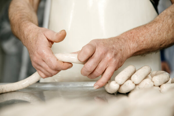 Hände die Wurst verarbeiten