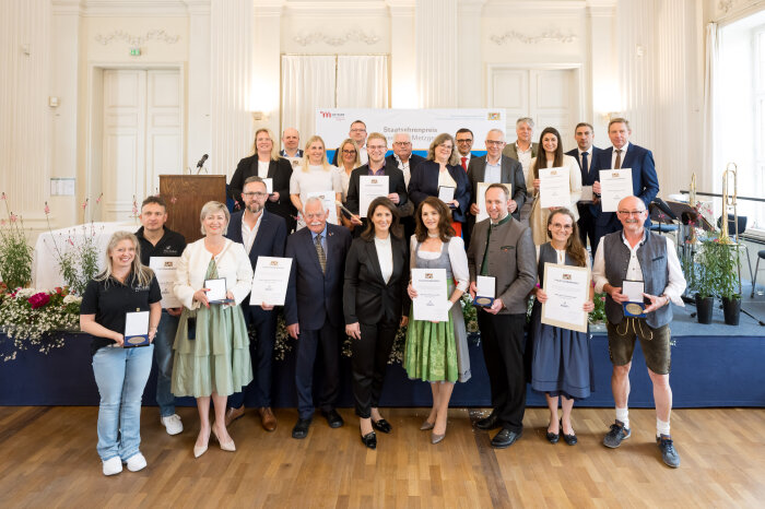 Staatsministerin Michaela Kaniber gemeinsam mit den Preisträgern und weiteren Teilnehmern des Staatsehrenpreises im Max-Joseph-Saal der Münchner Residenz.