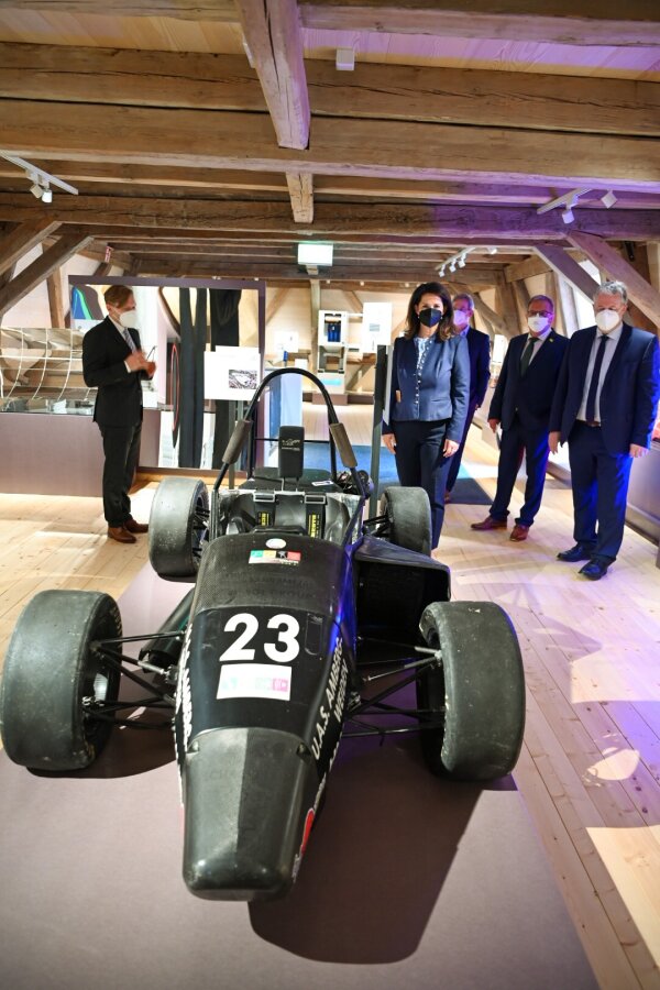 Ministerin Michaela Kaniber im Bergbau- und Industriemuseum in Theuern hinter einem Rennwagen.