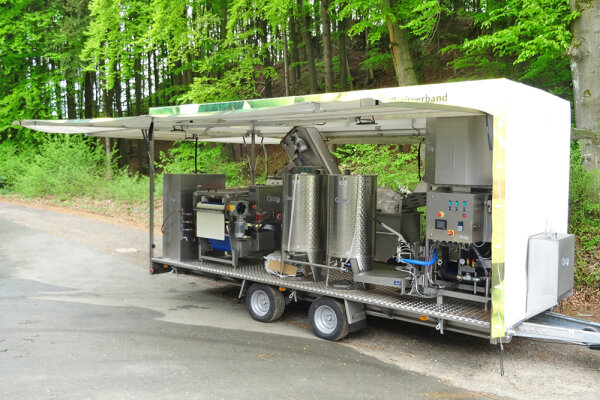 Mobile Obstpresse mit aufgeklapptem Vordach am Straßenrand