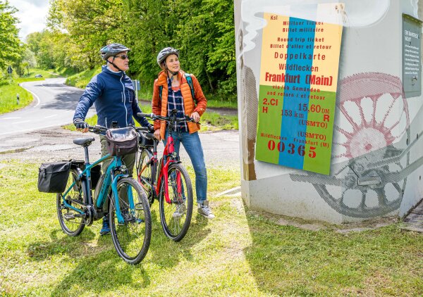 Zwei Radfahrer vor eine Plakat