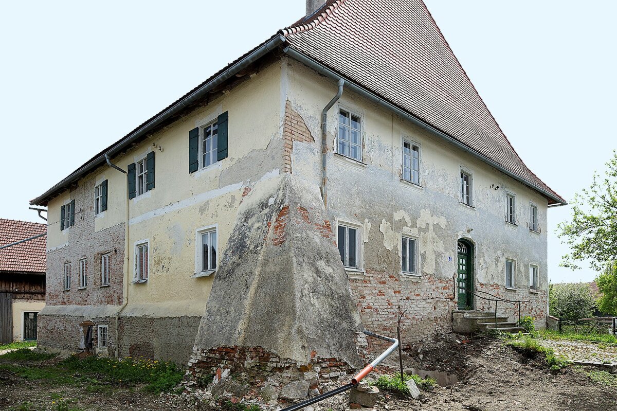 Zustand des Schlosses vor der Sanierung ohne Fensterläden und mit beschädigtem Verputz und Fassadenanstrich