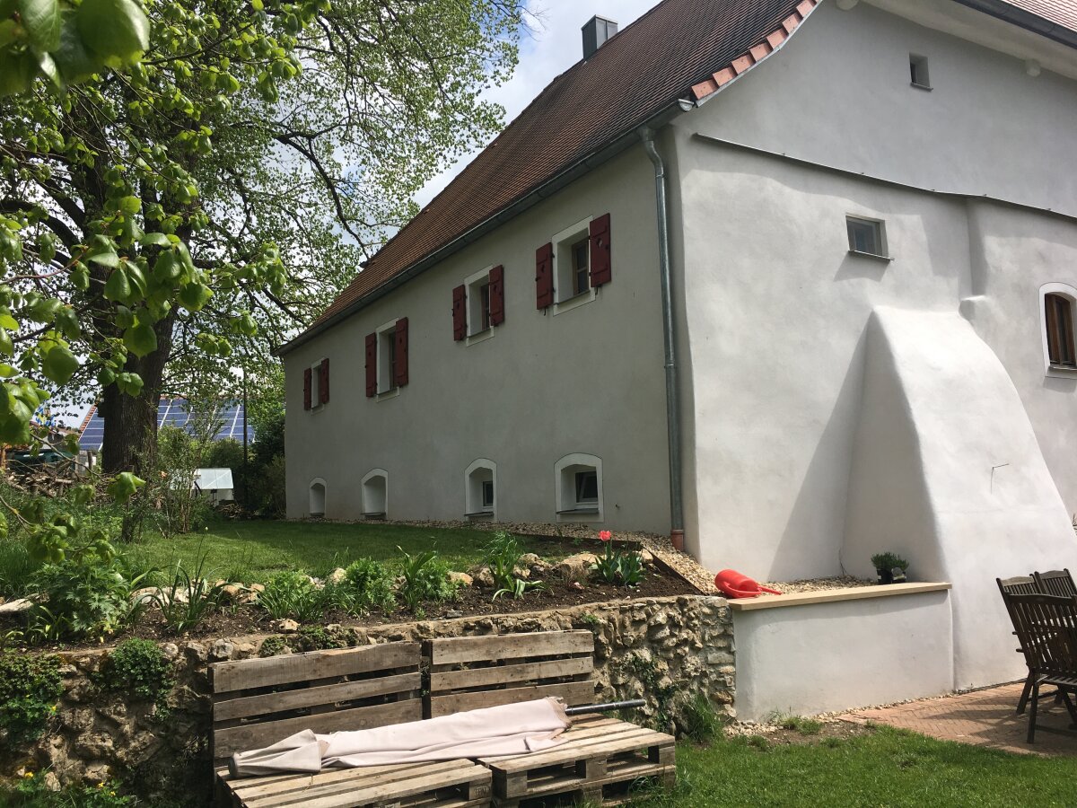 Eine gemütliche Holzbank ziert die Rückansicht des Mühlengebäudes und lädt zum verweilen ein.