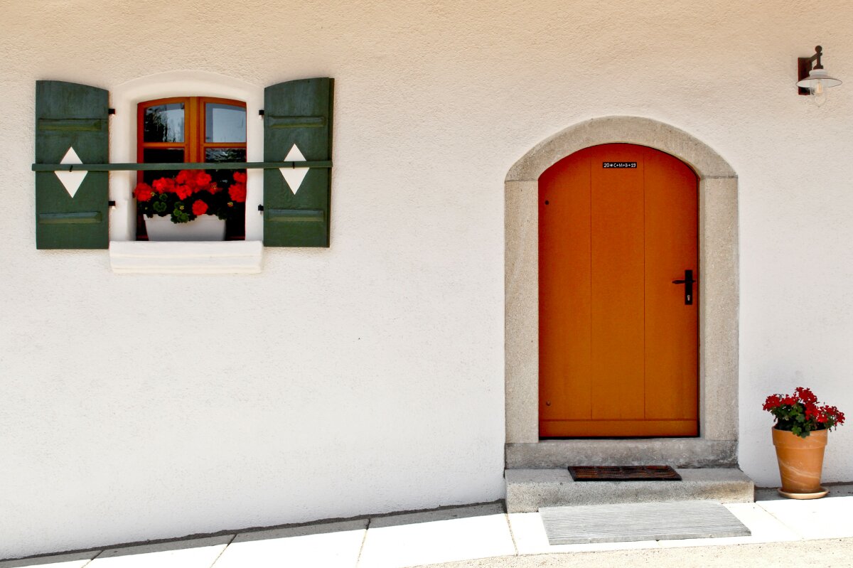 Die restaurierte Eingangstür des Dreisethof ist erkennbar. Daneben ist ein kleines, grünes Fenster angebracht. 
