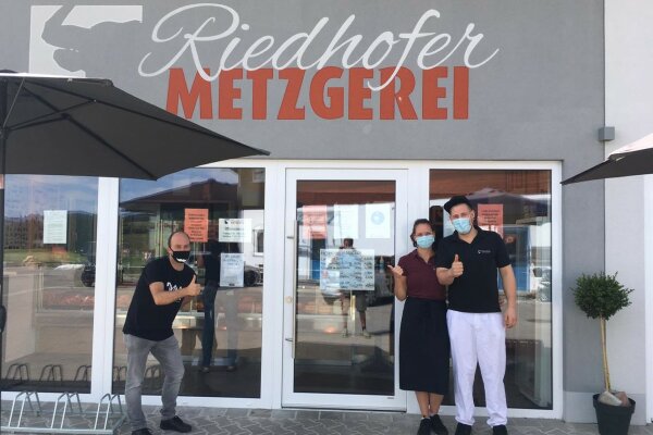 Eine Frau und zwei Männer vor der Metzgerei Riedhofer.