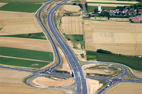 Teilstück der Autobahn mit Auffahrt; Trasse teilt landwirtschaftliche Grundstücke oder macht sie unförmig