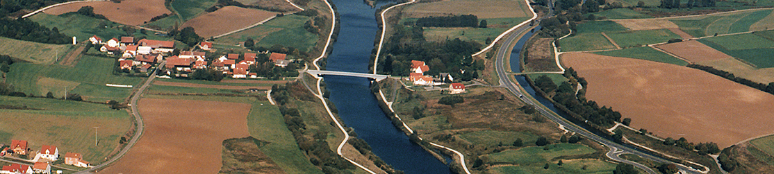 Donaukanal bei Plankstetten von links nach rechts: Landschaft, kleines Dorf, Geh- und Radweg, Brücke über Kanal, Geh- und Radweg, Weiler, Bundesstraße, Landschaft