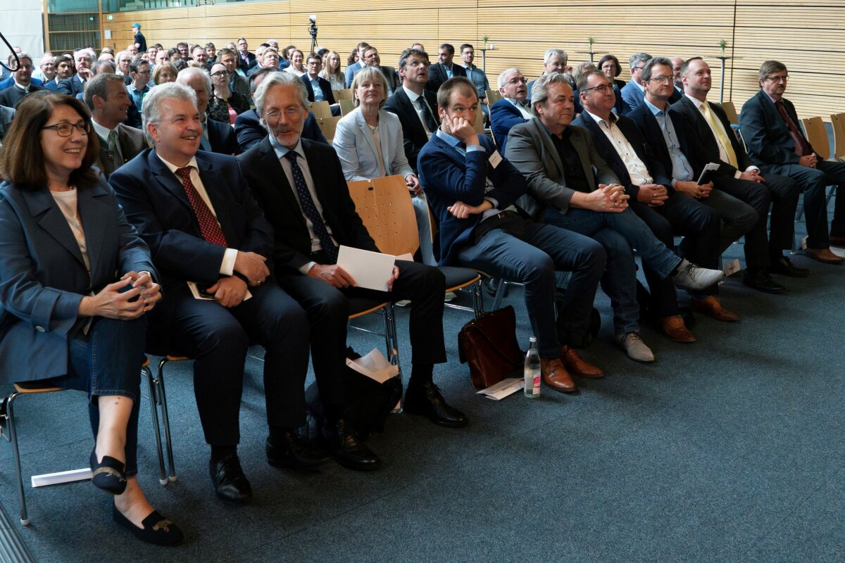 Viele Menschen sitzen auf Stühlen und hören sich den Vortrag