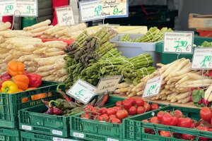 Marktstand mit weißem und grünem Spargel, Tomaten und Paprika