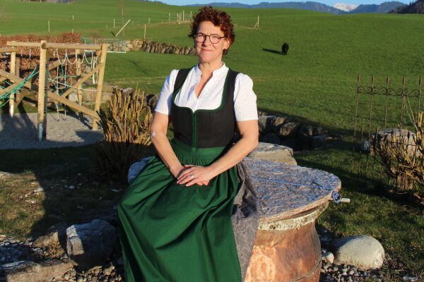 Brigitte Schädler sitzt auf einem abgedeckten Brunnen