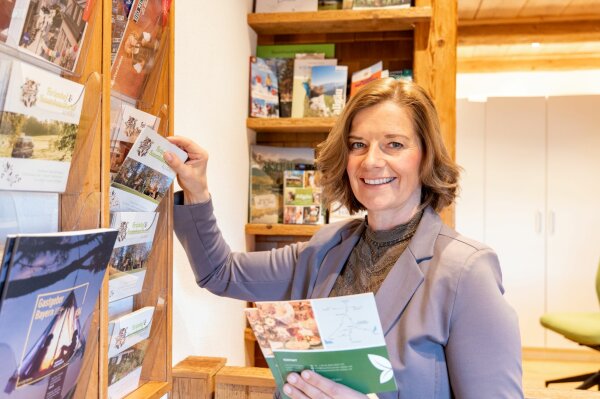 Katharina Zinnecker räumt Prospekte in ein Wandregal.