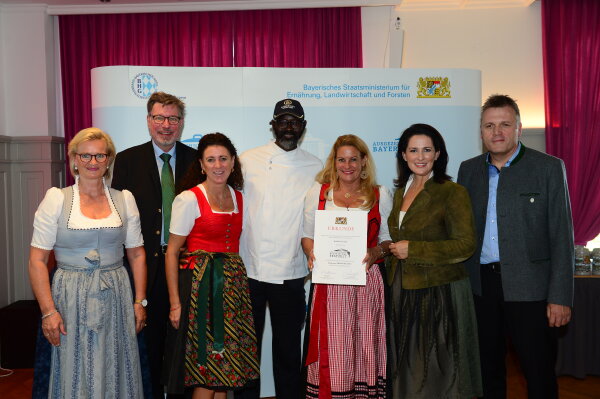 v.l.: Angela Inselkammer, Georg Schneider VI, Anela Ofenstein, Silja Schrank-Steinberg, Massamba Diagne, Staatsministerin Michaela Kaniber, Stefan Stang
