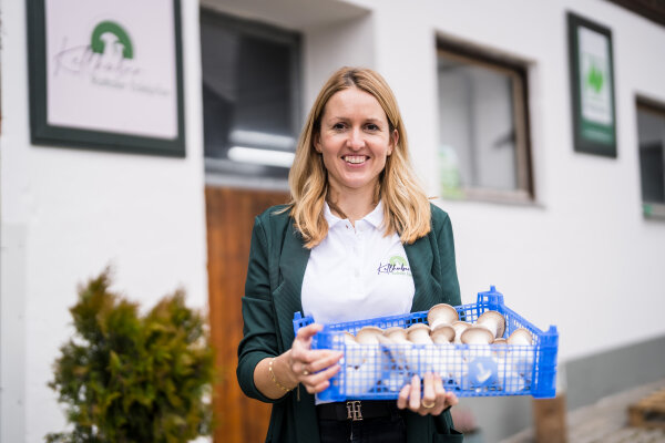 Maritta Kellhuber hält eine Kiste mit Edelpilzen in der Hand.