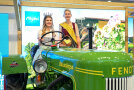 Zwei junge Frauen sitzen auf einem alten Fendt Traktor