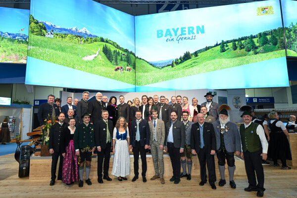Gruppenbild vor Plakatwand Bayern ein Genuss