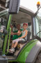 Ein Mädchen mit dem Bauer winken aus einem Traktor