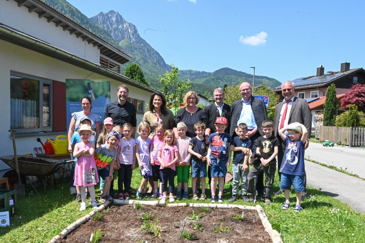 Landwirtschaftsministerin Michaela Kaniber (3. v. l.) gemeinsam mit Vertretern der Gemeinde Piding, des Landkreises und der Biosphären-Region Berchtesgadener Land sowie Personal und Vorschulkindern des Katholischen Kindergartens Maria Geburt. 