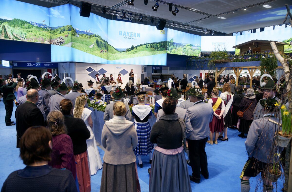 Bayernhalle auf dem Gelände der Grünen Woche 2024: Ministerin Michaela Kaniber steht am Rednerpult und hält die Eröffnungsrede. Das Publikum hört zu. 