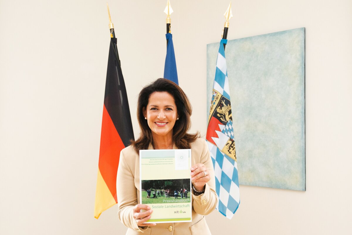 Landwirtschafsministerin Kaniber hält Handbuch Soziale Landwirtschaft in den Händen